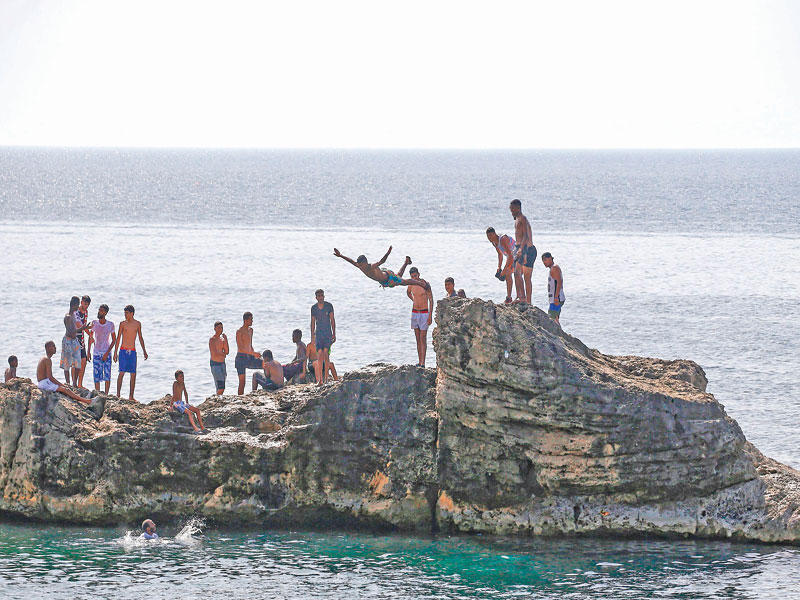  ليبيون يسبحون على ساحل طرابلس أمس الأول (أ ف ب) 