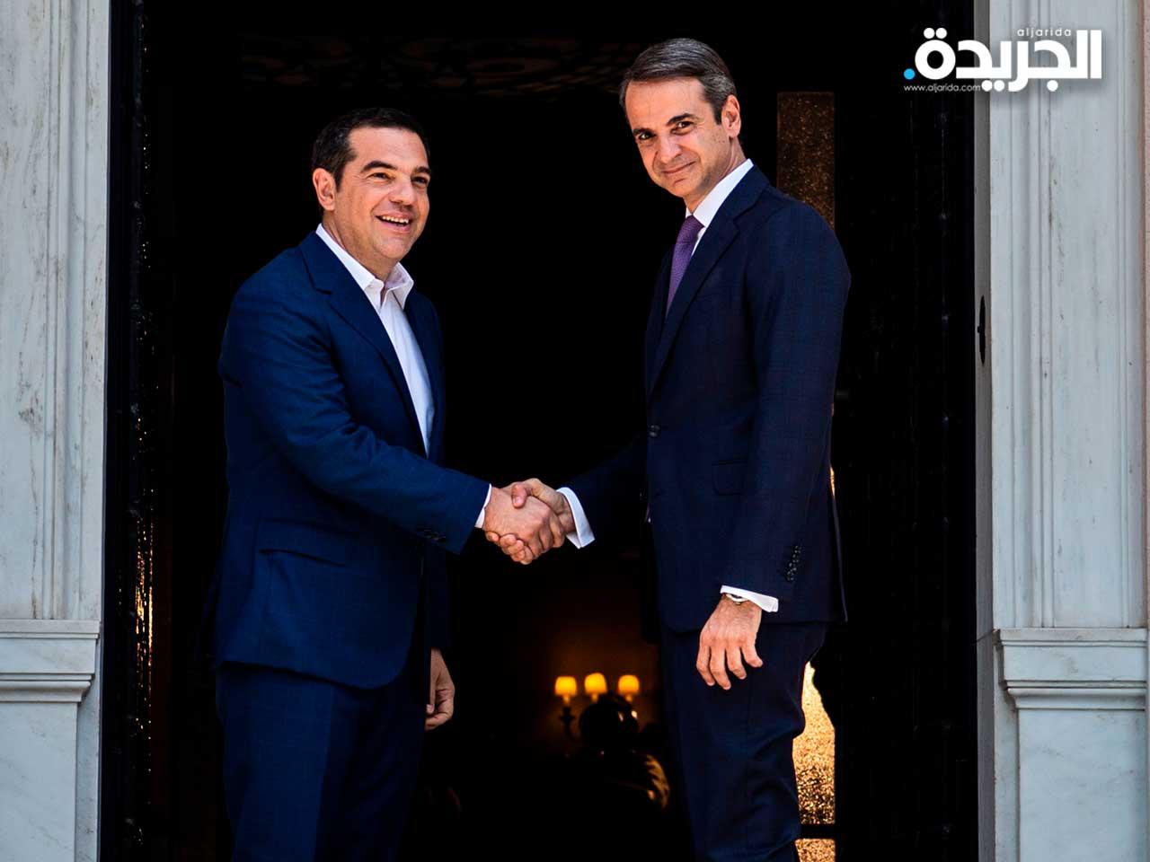  رئيس الوزراء اليوناني المعين حديثًا كيرياكوس ميتسوتاكيس (يمين) يصافح رئيس الوزراء السابق ألكسيس تسيبراس في قصر ماكسيموس في أثينا