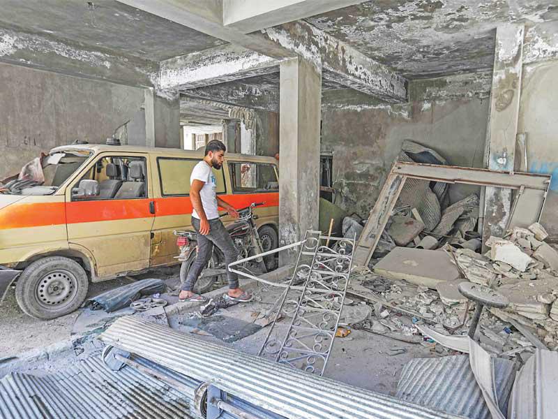 سوري يتفقد مرآب مشفى جسر الشغور المدمر في غارة للنظام أمسt (أ ف ب)