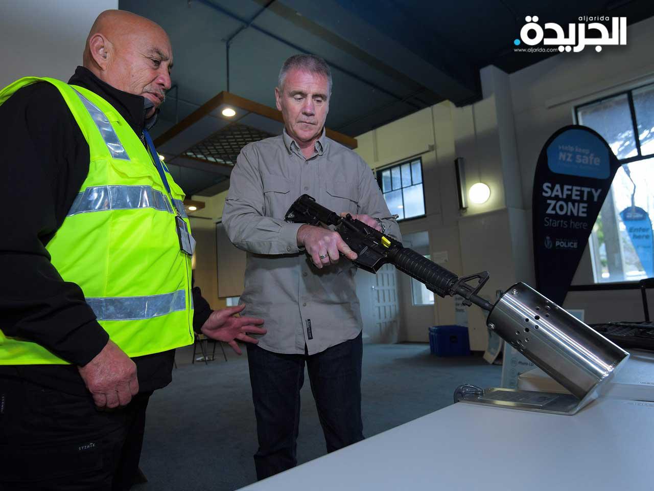  ضباط شرطة نيوزيلنديين يتعاملون مع مثال بندقية في معاينة صحفية قبل مخطط إعادة شراء الأسلحة