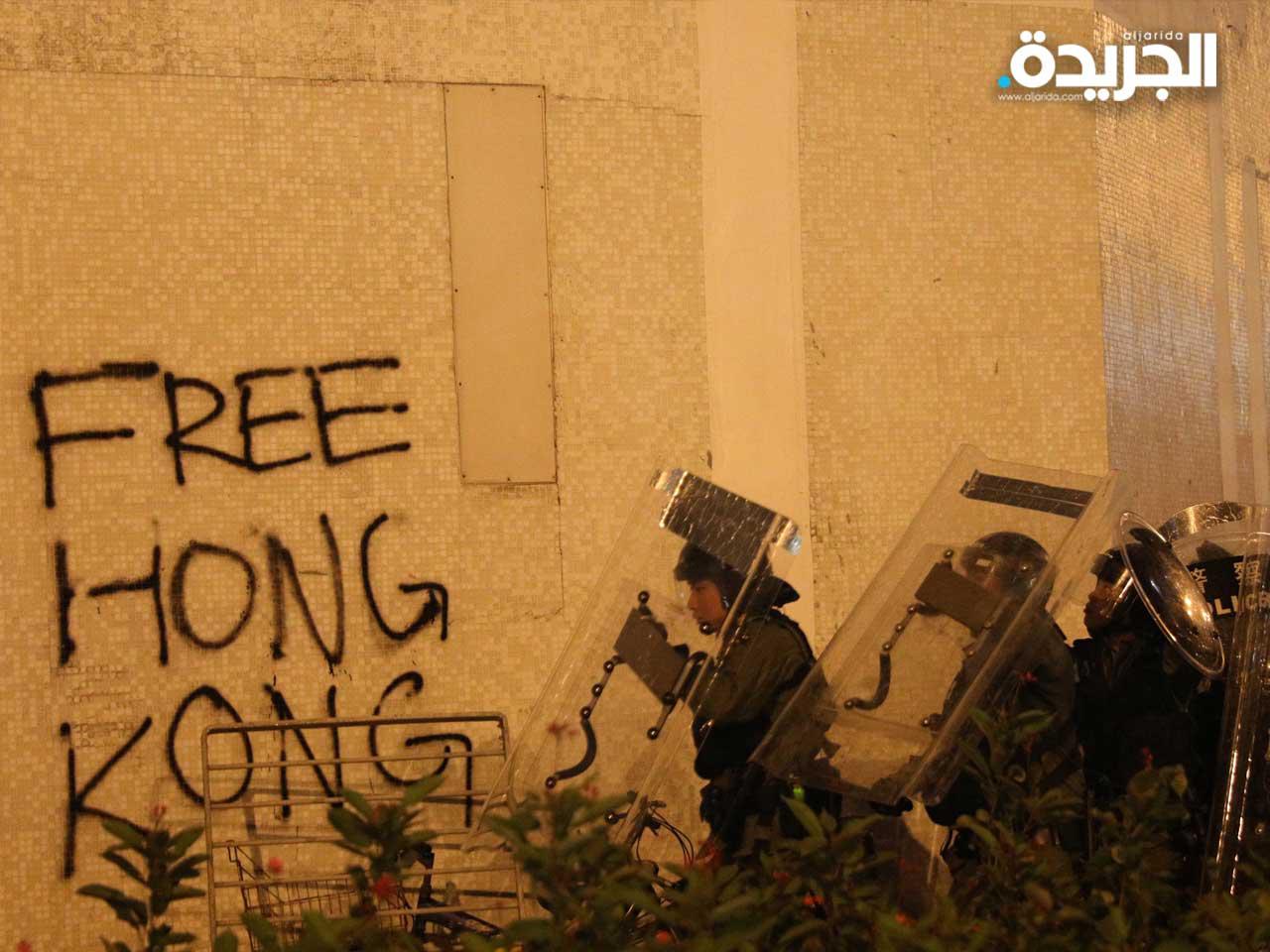 رجال الشرطة يحتفظون بالدروع بينما يحتج المتظاهرون ضد مشروع قانون تسليم المجرمين خلال مظاهرة حاشدة في شاتين ، هونغ كونغ