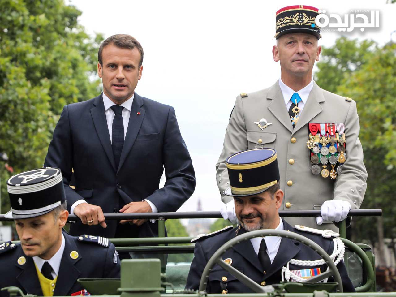 الرئيس الفرنسي إيمانويل ماكرون في مركبة بجانب رئيس أركان الجيش الفرنسي الجنرال فرانسوا ليكوينتر أثناء استعراضهم للقوات