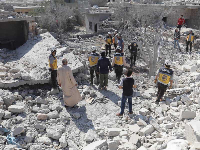 أفراد من الدفاع المدني السوري والمدنيون يتجمعون في أعقاب غارة جوية للنظام على قرية الكفرية في محافظة إدلب السورية