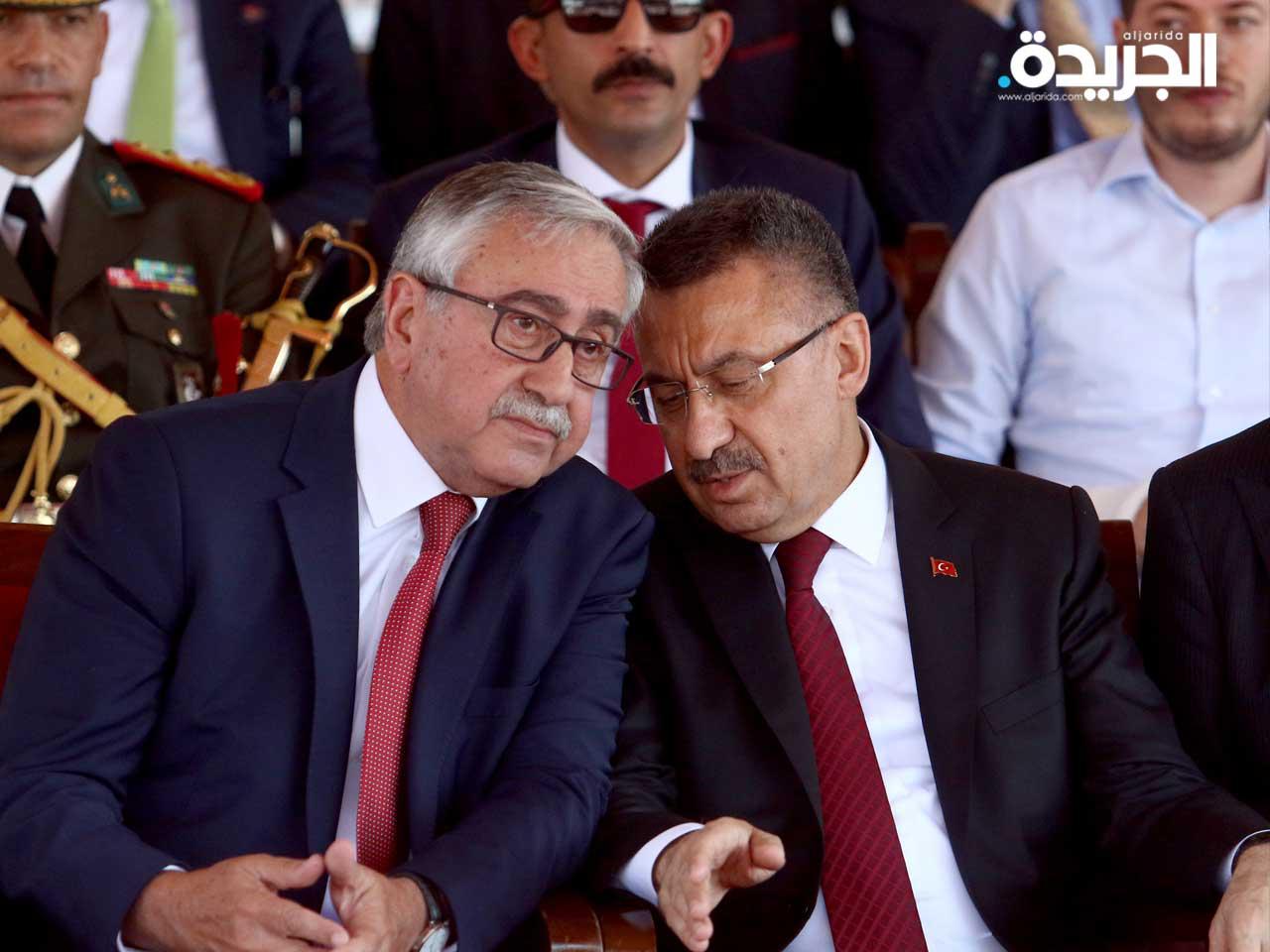  زعيم القبارصة الأتراك مصطفى أكينشي ونائب الرئيس التركي فات أوكتاي أثناء استعراض للاحتفال بالغزو التركي لقبرص