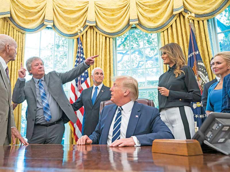 ترامب محاطاً برائدي الفضاء باز ألدرين ومايكل كولينز وأندرو أرمسترونغ ابن الرائد الراحل نيل أرمسترونغ في البيت الأبيض أمس الأول (اي بي ايه)