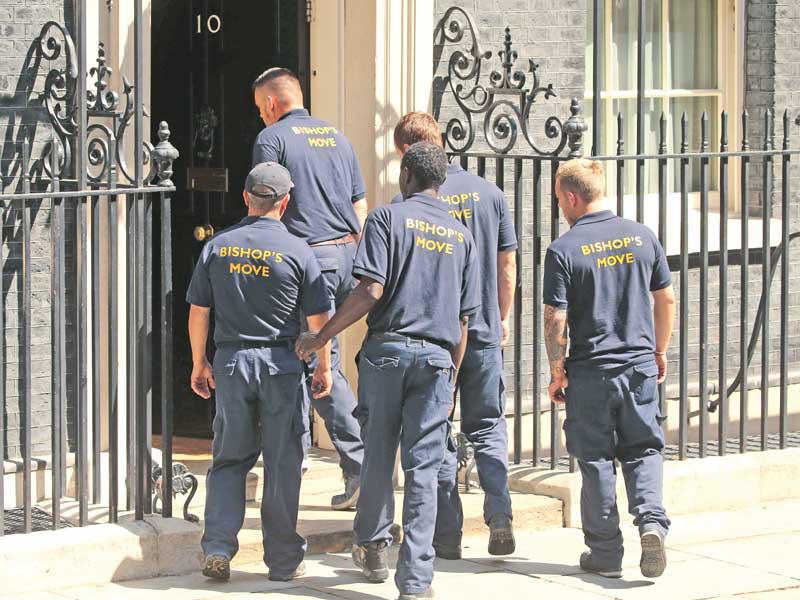 عمال يدخلون الى مقر الحكومة امس الأول لنقل أغراض جونسون الخاصة (أ ف ب)