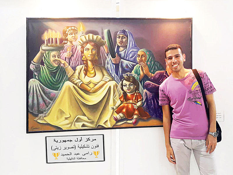 رامي عبد الحميد إلى جانب لوحته الفائزة 