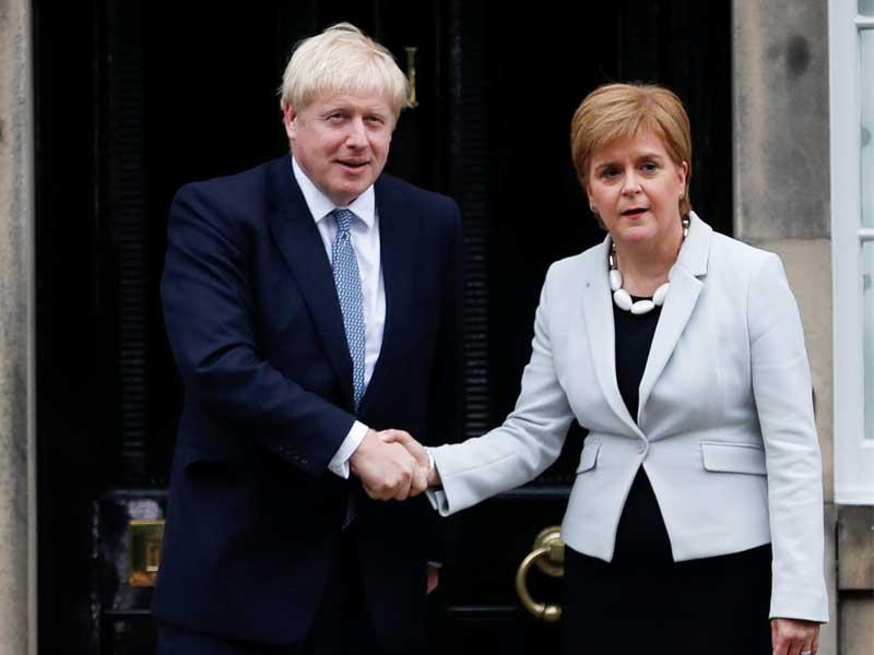 رئيس الوزراء البريطاني بوريس جونسون يصافح الوزيرة في اسكتلندا نيكولا ستورجيون في بيت بوت في أدنبرة