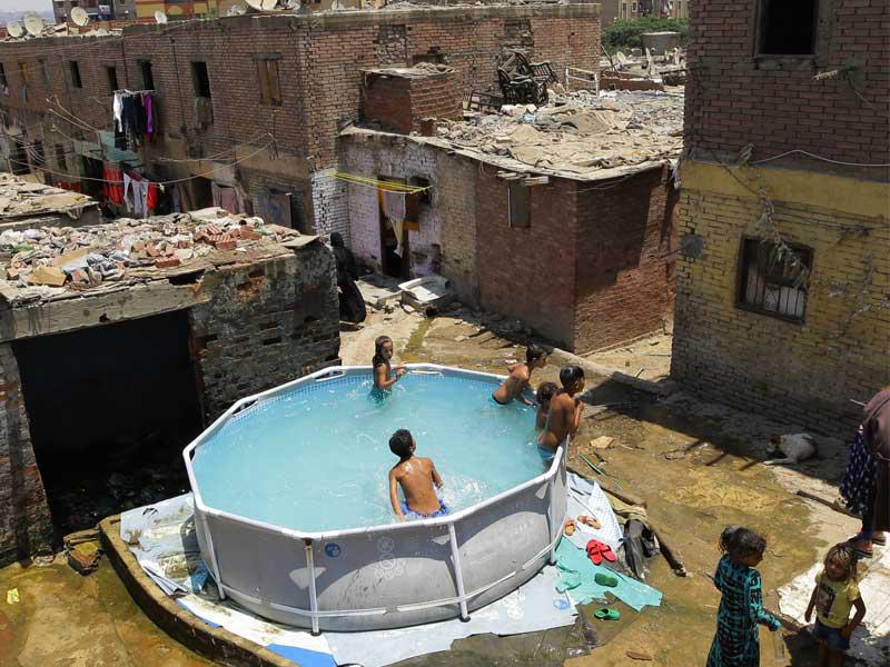 أطفال مصريون في حوض سباحة مؤقت في حي منشية ناصر ، القاهرة ، مصر