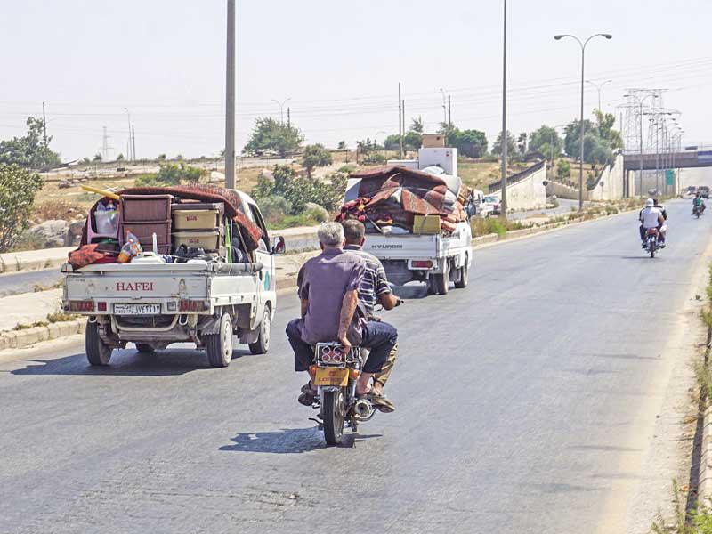 عائدون إلى إدلب على طريق باب الهوى أمس (أ ف ب)