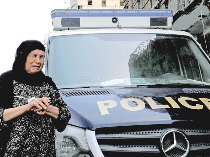 سيدة تنتحب أمام سيارة للشرطة قرب معهد الأورام في القاهرة أمس    (رويترز)