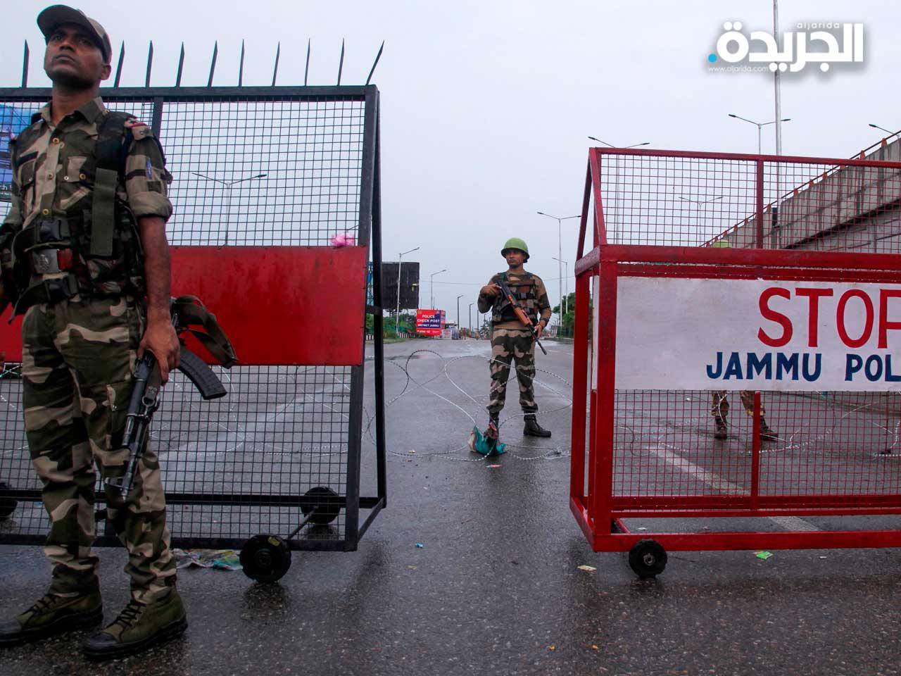 أفراد الأمن يقفون عند حاجز على الطريق 