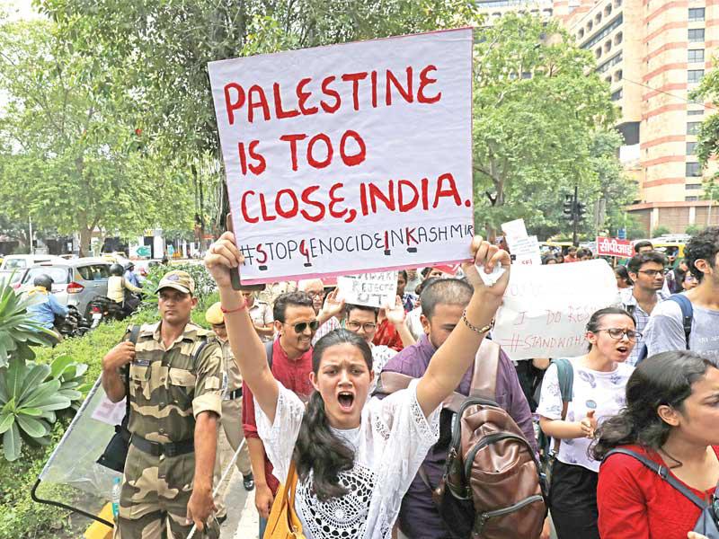 سيدة ترفع لافتة كتب عليها «فلسطين قريبة جداً» خلال تظاهرة في دلهي أمس احتجاجاً على قرار إلغاء الوضع الخاص بكشمير            (رويترز)