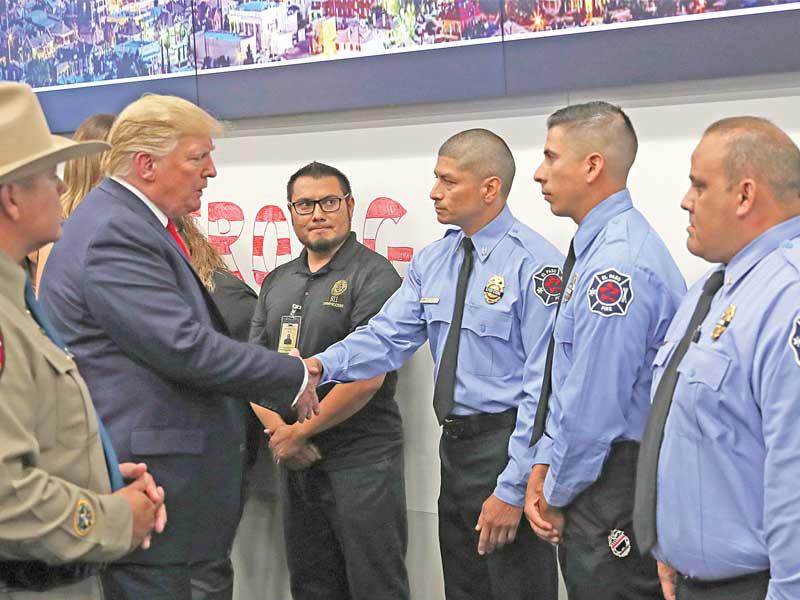 ترامب مصافحاً مجموعة من رجال الأمن الذين شاركوا في عملية اعتقال مطلق النار الذي قتل 22 شخصاً في إل باسو أمس الأول (رويترز)