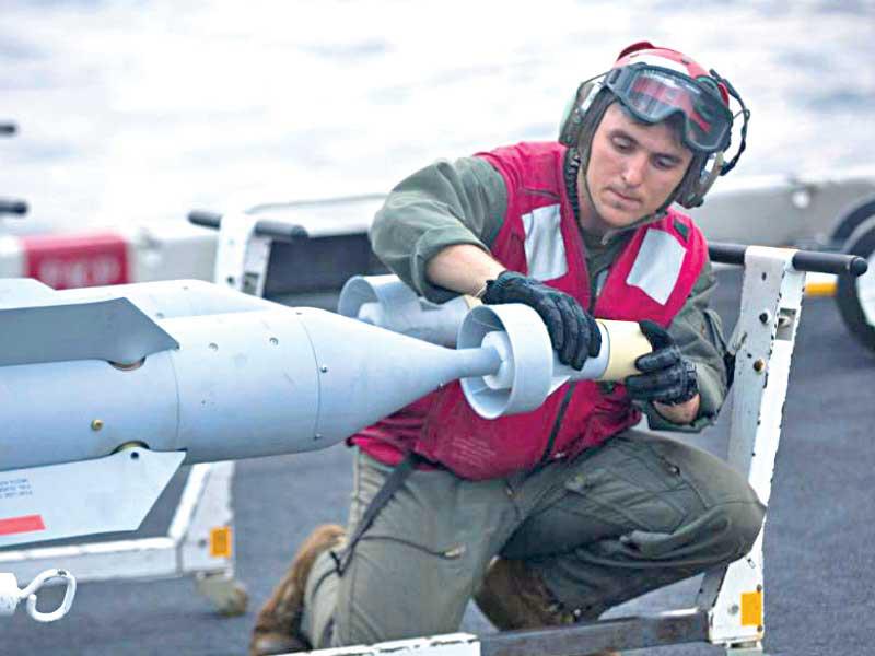 بحار على متن حاملة الطائرات الأميركية «آبراهام لينكولن» يضع حماية على مقدمة صاروخ