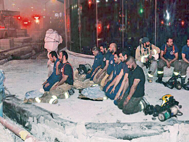 رجال الإطفاء أثناء صلاتهم بعد السيطرة على الحريق