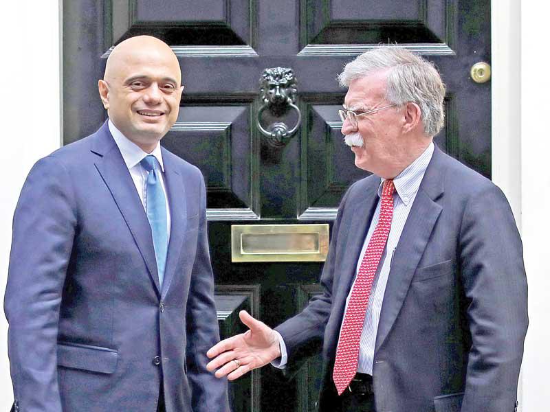 وزير المالية البريطاني ساجد جاويد مستقبلاً بولتون أمام مقر الحكومة في لندن أمس (أ ف ب)