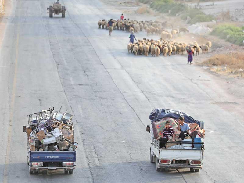 شاحنتان تحملان مقتنيات فارين من معارك إدلب أمسt (أ ف ب)