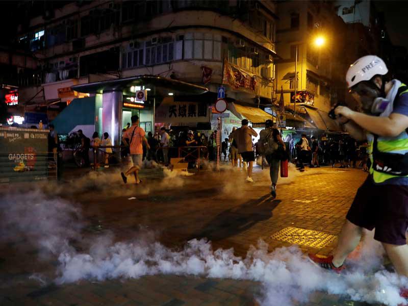 الناس يفرون من الغاز المسيل للدموع الذي أطلقته الشرطة لتفريق المتظاهرين