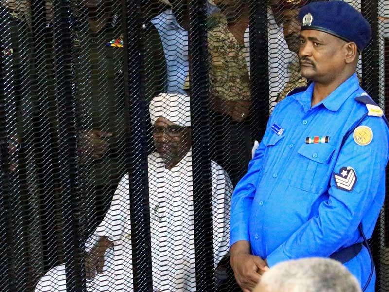 البشير خلف القضبان خلال محاكمته أمس (رويترز)