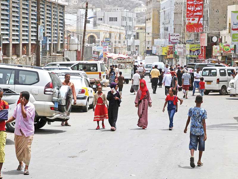 يمنيون في أحد شوارع عدنt (رويترز)