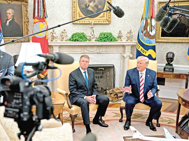 ترامب خلال استقباله نظيره الروماني كلاوس يوهانيس في البيت الأبيض أمس الأول (إي بي آيه)