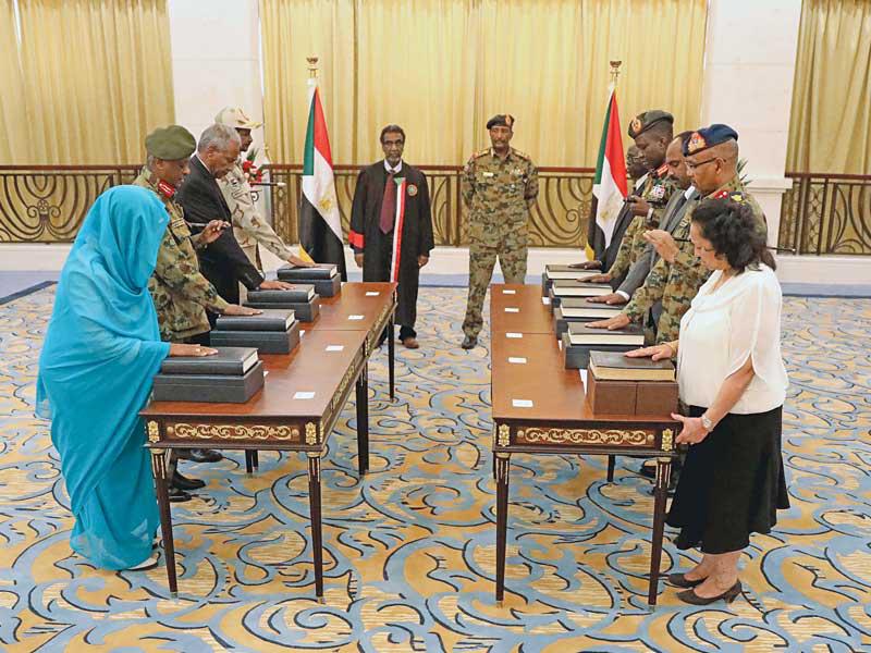 أعضاء المجلس السيادي يؤدّون اليمين أمام البرهان وعبّاس بالقصر الجمهوري في الخرطوم أمس (أي بي ايه)
