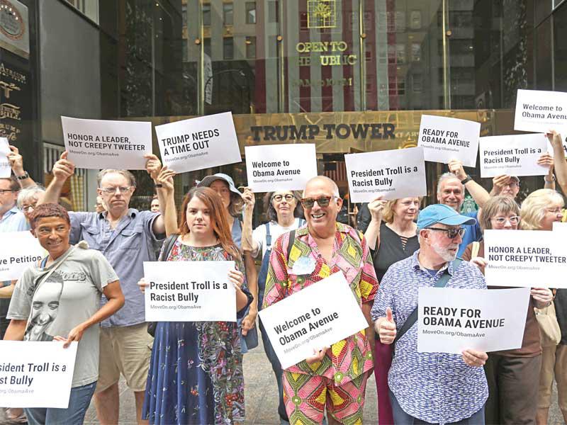 متظاهرون أمام برج ترامب في نيويورك يطالبون باطلاق اسم سلفه باراك أوباما على مقطع من جادة فيفث أفنيو أمس الأولt  (رويترز)