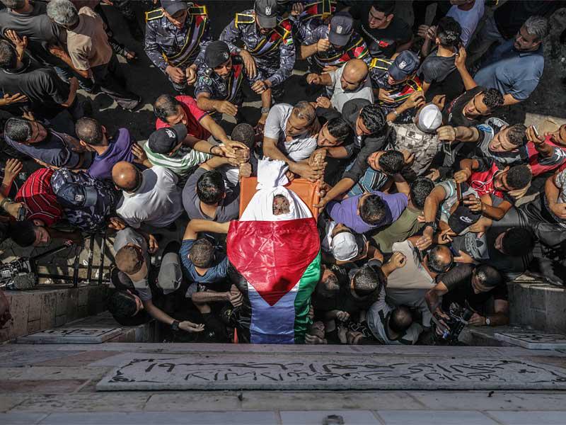 يحمل فلسطينيون إحدى جثث ثلاثة من رجال شرطة حماس الذين قُتلوا في انفجار في اليوم السابق خلال مراسم تشييعهم في مسجد العمري في مدينة غزة