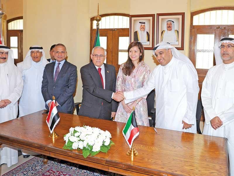 الجارالله واليوسف خلال مراسم تسليم الكتب في المعهد الدبلوماسي أمس