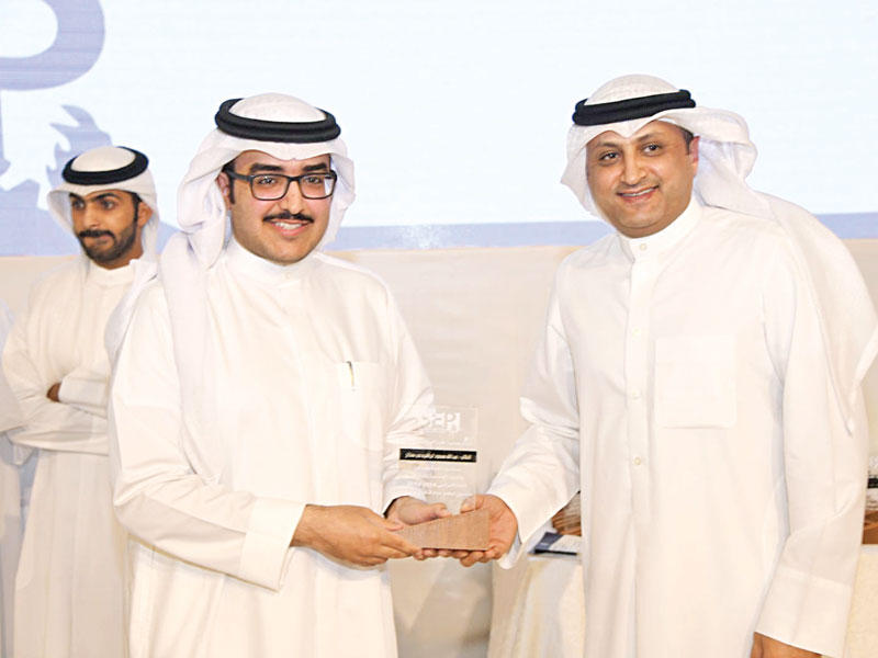 محمد الفارس متسلماً درعاً تكريمية من عبدالعزيز الهاجري