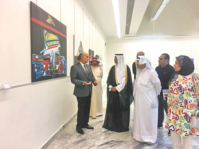 د. الدويش يستمع لشرح من شلا عن إحدى لوحاته بالمعرض 