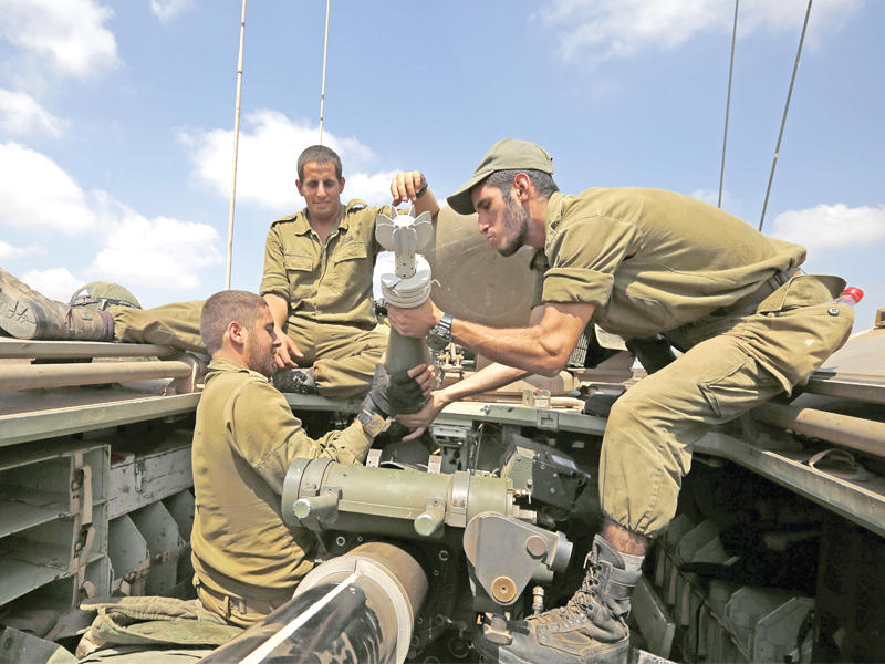 جنود إسرائيليون يجهزون قذيفة هاون بمرتفعات الجولان المحتل أمس   (أ ف ب)