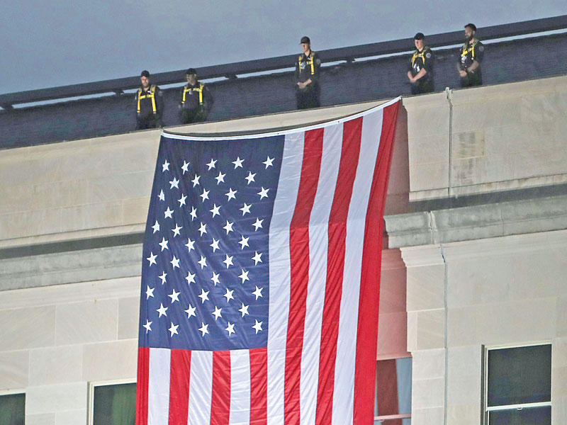 علم أميركي معلّق على أحد جوانب مبنى «البنتاغون» أمس       (أ ف ب)
