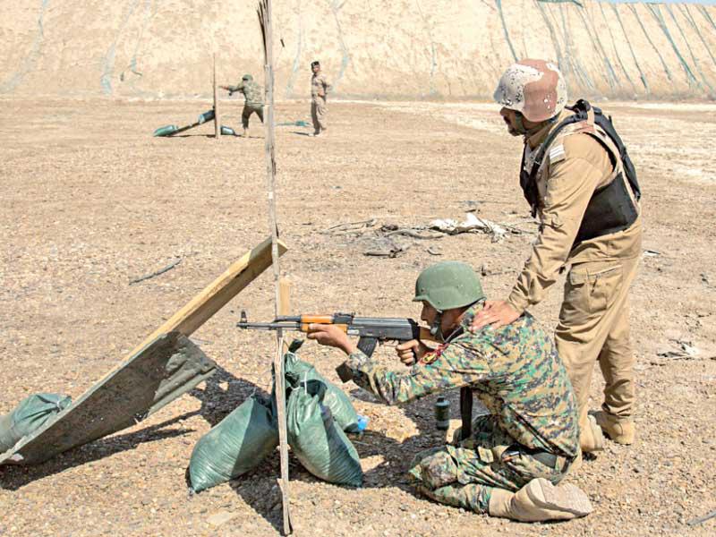 جنديان عراقيان في «معسكر التقدّم» يتدرّبان على إطلاق الرصاص أمس الأول (سنتكوم)