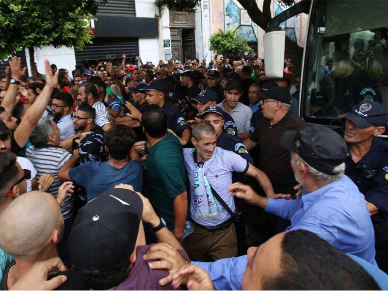 ضباط الشرطة يقفون حذرًا أثناء محاولة المتظاهرين شق طريقهم أثناء احتجاج برفض إعلان الانتخابات الجزائرية لشهر ديسمبر في الجزائر العاصمة ، الجزائر