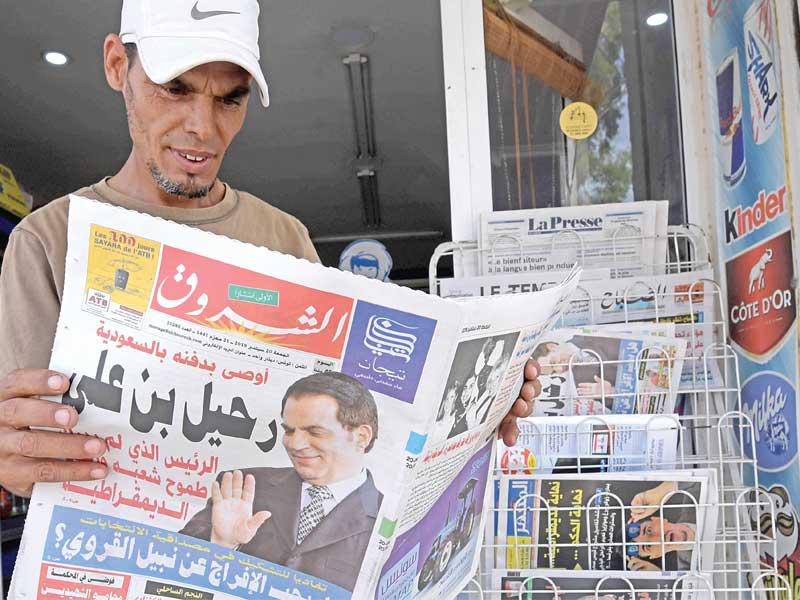 تونسي يتفقد الأخبار عن وفاة بن علي أمس الأول (أ ف ب)