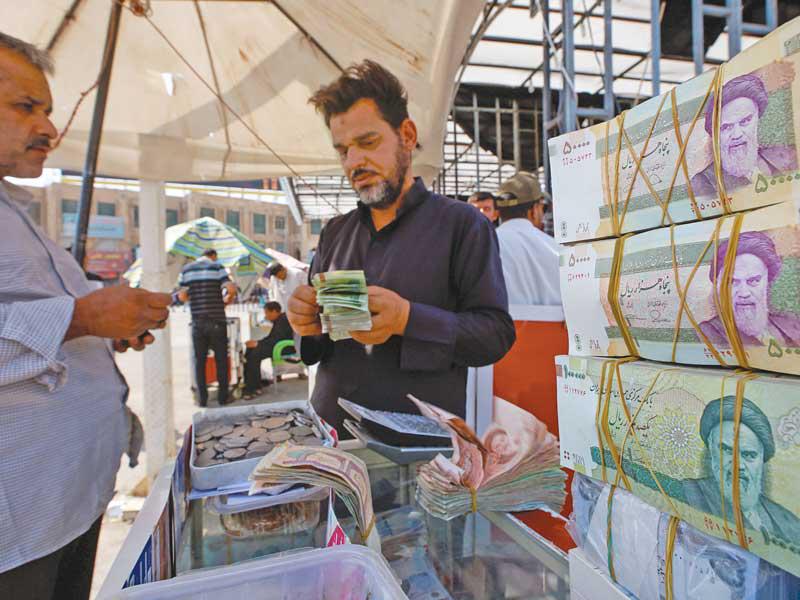 صرافون إيرانيون في النجف أمس (رويترز)