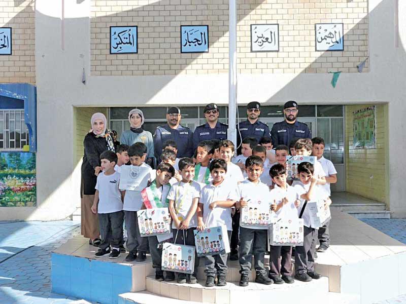 طلاب ومديرة مدرسة الملا سعود الصقر الابتدائية مع رجال الشرطة