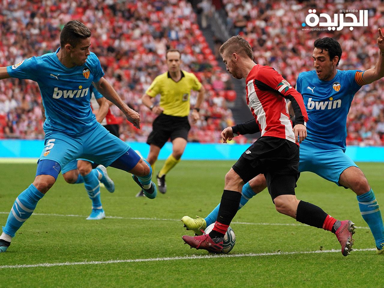  مدافع فالنسيا البرازيلي غابرييل باوليستا (يسار) ولاعب خط الوسط الإسباني فالنسيا داني باريجو (يسار) مع مهاجم أتليتيك بلباو الإسباني إيكر مونيان