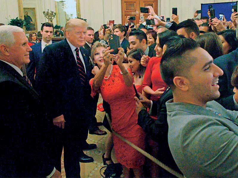 سيدة تلتقط «سيلفي» مع ترامب خلال لقاء في البيت الأبيض أمس الأول (أ ف ب)