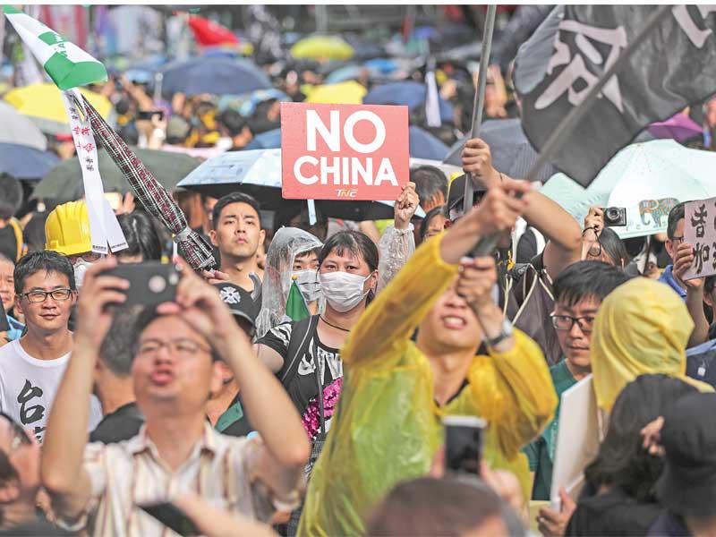 متظاهرون في العاصمة التايوانية خلال مسيرة مؤيدة لهونغ كونغ أمس (اي بي آي)