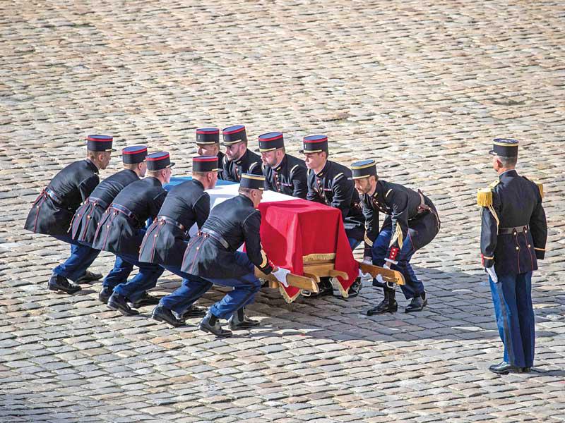 جنود من حرس الشرف يرفعون نعش شيراك في ثكنة «ديزينفاليد» في باريس أمس (اي بي ايه)
