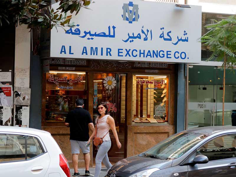 سيدة تمرّ قرب محل للصيرفة في بيروت أمس (أ ف ب)