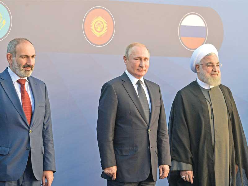 رئيس وزراء أرمينيا نيكول باشينيان مستقبلا بوتين وروحاني في يريفان أمس (أ ف ب)