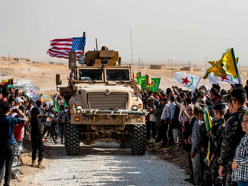 أكراد حول مدرعة أميركية خلال مظاهرة ضد تركيا أمس على مشارف رأس العين أمس الأول (أ ف ب)