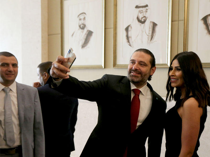 الحريري يلتقط «سيلفي» مع مشاركة في المؤتمر الاستثماري في أبوظبي أمس (رويترز)