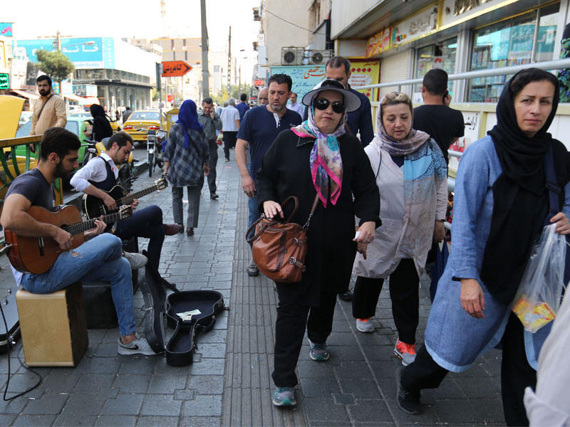 شابان يعزفان بأحد شوارع طهران أمس (أ ف ب)