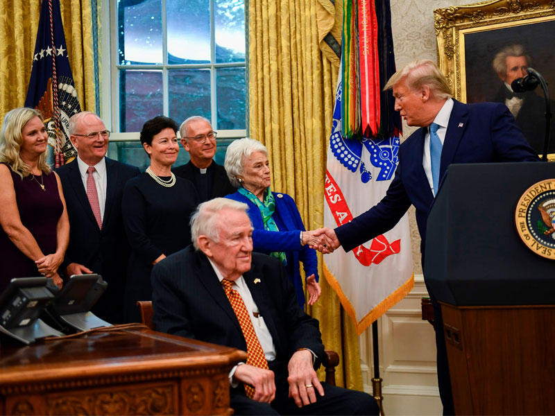 ترامب مصافحاً زوجة المدّعي العام السابق ادوين ميز قبل تقليده ميدالية الحرية في البيت الأبيض أمس الأول (أ ف ب)