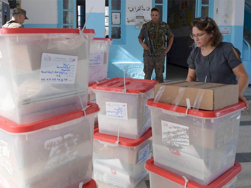 سلوى بوسنينة ، مديرة محطة بولينج ، تتلقى صناديق الاقتراع المغلقة والأوراق الانتخابية في حي أريانة في تونس العاصمة